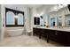 Elegant bathroom with a soaking tub, dark wood vanities, and a chandelier at 31709 N 16Th Ave, Phoenix, AZ 85085