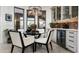 Elegant dining area featuring a glass-top table, stylish chairs, and a built-in wine fridge at 31709 N 16Th Ave, Phoenix, AZ 85085