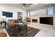 Comfortable living room with a stone fireplace, a large window, stylish furniture, and ceiling fan at 31709 N 16Th Ave, Phoenix, AZ 85085