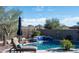 Relaxing backyard pool with a blue tile waterfall feature surrounded by desert landscaping and privacy fencing at 31709 N 16Th Ave, Phoenix, AZ 85085