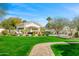 Lush backyard featuring a covered lounge area, sparkling pool, manicured lawn, and inviting pathway at 3246 E San Miguel Pl, Paradise Valley, AZ 85253