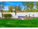 Lush backyard with a basketball court, manicured landscaping, a white perimeter wall, and ample space at 3246 E San Miguel Pl, Paradise Valley, AZ 85253