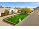 Lush front yard of a home with manicured lawn, vibrant landscaping, and a brick-paved driveway at 3246 E San Miguel Pl, Paradise Valley, AZ 85253