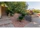 Backyard garden showing a brick patio with mature landscaping, bougainvillea, and a multi-tiered stone retaining wall at 3254 N Park St, Buckeye, AZ 85396