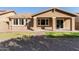 Backyard view showing landscaped area, grass, brick accents, and covered outdoor patio at 3254 N Park St, Buckeye, AZ 85396