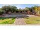 Expansive backyard featuring a multi-tiered stone patio and walkway, lush landscaping, and mature trees providing shade at 3254 N Park St, Buckeye, AZ 85396