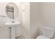 Half bathroom with pedestal sink, round mirror, and tiled floor at 3254 N Park St, Buckeye, AZ 85396