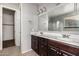 Bright bathroom featuring a double sink vanity with dark wood cabinets and a separate glass-enclosed shower at 3254 N Park St, Buckeye, AZ 85396