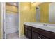 Bright bathroom featuring a single sink vanity, and a white tiled shower and tub combo at 3254 N Park St, Buckeye, AZ 85396