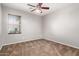 This bedroom features a ceiling fan, carpet, and a window providing natural light at 3254 N Park St, Buckeye, AZ 85396