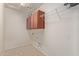 This laundry room features tile floors, overhead cabinets, and hookups for a washer and dryer at 3254 N Park St, Buckeye, AZ 85396