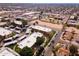 Drone image of apartment complex surrounded by parking, green spaces, and neighborhood amenities under a clear sky at 3601 W Tierra Buena Ln # 233, Phoenix, AZ 85053