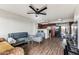 Bright living room featuring modern flooring, a ceiling fan, and an open layout with a view of the kitchen at 3601 W Tierra Buena Ln # 233, Phoenix, AZ 85053