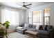 Bright living room with a comfortable gray sectional and lots of natural light from large windows at 3840 E Yeager Dr, Gilbert, AZ 85295