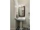 Stylish bathroom featuring a pedestal sink, decorative mirror, and black-and-white checkered floor at 4111 N 52Nd St, Phoenix, AZ 85018