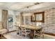 Elegant dining room featuring a brick accent wall, stylish lighting, and a rustic dining table at 4111 N 52Nd St, Phoenix, AZ 85018