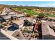 An aerial view of a beautiful desert home adjacent to a lush green golf course and scenic mountain backdrop at 41921 N Crooked Stick Rd, Anthem, AZ 85086