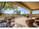 Inviting covered patio with brick pavers, comfortable seating, grill, and a beautiful desert view at 41921 N Crooked Stick Rd, Anthem, AZ 85086