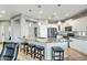 Open-concept kitchen with a large center island featuring granite countertop, bar stools, and modern stainless steel appliances at 41921 N Crooked Stick Rd, Anthem, AZ 85086