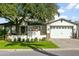 Charming white two-story home with a manicured lawn, mature trees, and a brick-paved driveway leading to an attached garage at 4208 E Sells Dr, Phoenix, AZ 85018