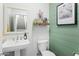 This powder room features a pedestal sink, wood accent wall, and decorative mirror at 4208 E Sells Dr, Phoenix, AZ 85018