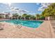 Outdoor pool area with lounge chairs, tables, umbrellas, and beautiful landscaping on a bright sunny day at 421 Leisure World --, Mesa, AZ 85206