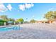 Resort-style pool area with a hot tub, lounge chairs, and umbrellas, set against a bright blue sky at 421 Leisure World --, Mesa, AZ 85206