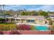 Aerial view of a home with a backyard pool, red brick fence, and mountain views at 4349 E Stanford Dr, Phoenix, AZ 85018