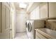 Functional laundry room featuring modern washer and dryer, ample cabinet space, and a utility sink at 4349 E Stanford Dr, Phoenix, AZ 85018