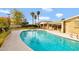 Swimming pool surrounded by patio, a brick house, and lush landscaping in the background at 4349 E Stanford Dr, Phoenix, AZ 85018