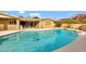 Backyard pool with a diving board, brick home, and palm trees in the distance at 4349 E Stanford Dr, Phoenix, AZ 85018