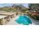 Gorgeous pool features a dolphin mosaic and lush landscaping, set against a backdrop of scenic mountain views at 4349 E Stanford Dr, Phoenix, AZ 85018