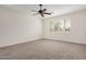 Spacious bedroom with neutral carpet, ceiling fan, and window with plantation shutters at 4376 S Summit E St, Gilbert, AZ 85297