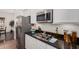 Close-up of stainless steel refrigerator, microwave, and cooktop on granite countertops at 4376 S Summit E St, Gilbert, AZ 85297