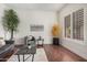 Bright living room with hardwood floors, gray furniture, a faux tree, and shuttered windows at 4376 S Summit E St, Gilbert, AZ 85297