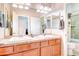 Full bathroom with double sinks, tile counters, wood cabinets, toilet, and shower/tub combo at 4545 S Ellesmere St, Gilbert, AZ 85297