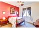 Bright bedroom with a red accent wall, vintage furniture, and natural light at 4545 S Ellesmere St, Gilbert, AZ 85297