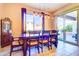 Bright dining room with a wooden table set, sliding glass door to backyard, and tiled floors at 4545 S Ellesmere St, Gilbert, AZ 85297