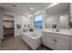 Bright bathroom features a large soaking tub, double vanity, walk-in closet, and tiled floor at 4593 W Bush Bean Way, San Tan Valley, AZ 85144