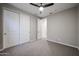 Minimalist bedroom featuring a ceiling fan, large closet, neutral tones, and carpeted floors at 4593 W Bush Bean Way, San Tan Valley, AZ 85144