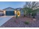 Inviting single-Gathering home with desert landscaping, a paved driveway, and exterior lighting at 4593 W Bush Bean Way, San Tan Valley, AZ 85144