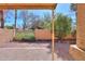 Enclosed backyard with desert landscaping, brick borders, and a covered patio area at 4843 W Del Rio St, Chandler, AZ 85226