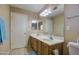 Bathroom featuring double sinks, tiled floors, wood cabinets, and a large mirror at 5071 W Warren Dr, Casa Grande, AZ 85194