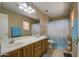 Bathroom featuring double sinks, wood cabinets, tiled floors, and a shower tub with a curtain at 5071 W Warren Dr, Casa Grande, AZ 85194