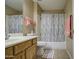 Well-lit bathroom featuring a shower-tub combo and a wooden vanity with a sink at 5071 W Warren Dr, Casa Grande, AZ 85194