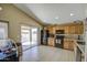 Modern kitchen featuring black appliances, oak cabinetry, tile flooring, and sliding patio doors at 5071 W Warren Dr, Casa Grande, AZ 85194