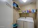 Efficient laundry room with modern washer and dryer, and ample shelving for storage at 5071 W Warren Dr, Casa Grande, AZ 85194