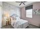 Charming bedroom featuring a world map accent wall, a ceiling fan, a plush bed and a window with blinds at 5106 E Umber Rd, San Tan Valley, AZ 85143