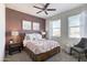 Cozy bedroom featuring a plush bed, accent tables, elegant lamps, large windows and a statement plum wall at 5106 E Umber Rd, San Tan Valley, AZ 85143