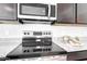 Close-up of a stainless steel stove and microwave, showcasing modern kitchen appliances at 5106 E Umber Rd, San Tan Valley, AZ 85143